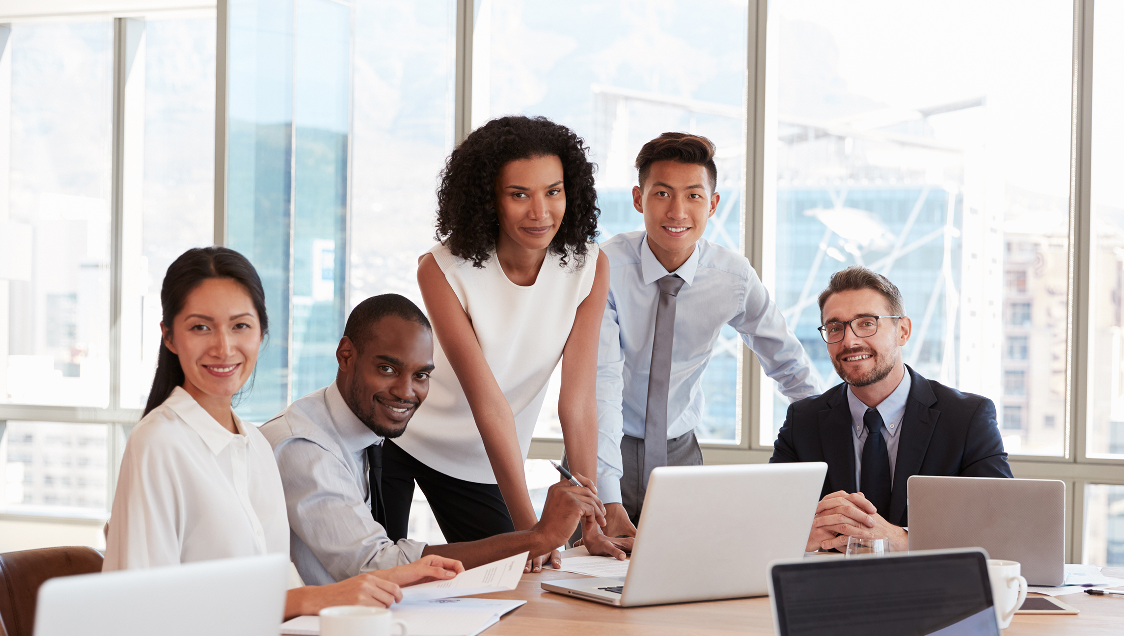 Portrait,Of,Businesspeople,Meeting,Around,Table,In,Office